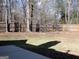 Large, partially grassy backyard with a wooden fence and mature trees at 180 Sunderland Cir, Fayetteville, GA 30215