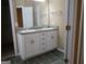 Bathroom vanity with double sinks, white cabinetry, and a large mirror at 180 Sunderland Cir, Fayetteville, GA 30215