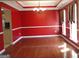 A dining room with red walls, hardwood floors, and a modern chandelier at 180 Sunderland Cir, Fayetteville, GA 30215