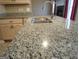 Close-up of the kitchen island, showcasing the speckled granite countertop and stainless steel sink at 180 Sunderland Cir, Fayetteville, GA 30215