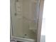 Bathroom shower stall with clear glass doors, built-in shelving, and a handrail for accessibility at 180 Sunderland Cir, Fayetteville, GA 30215