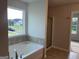Relaxing soaking tub next to glass enclosed shower in this primary bathroom at 4130 Chapel Hill Reserve, Douglasville, GA 30135