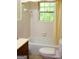 This bathroom features a bathtub with a shower, a window with natural light, and a neutral color scheme at 2102 Mulkey Sw Rd, Marietta, GA 30008