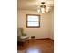 Bedroom features a ceiling fan, hardwood floors, and a cozy green chair at 2102 Mulkey Sw Rd, Marietta, GA 30008