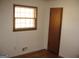 Cozy bedroom with hardwood floors, a window, and wood paneled door at 2102 Mulkey Sw Rd, Marietta, GA 30008