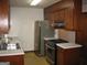 Compact kitchen with stainless-steel appliances and double bowl sink with wooden cabinets at 2102 Mulkey Sw Rd, Marietta, GA 30008