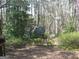 An exterior view of a storage shed surrounded by lush greenery and trees at 2102 Mulkey Sw Rd, Marietta, GA 30008