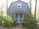 This is an exterior view of shed surrounded by green foliage, featuring double doors at 2102 Mulkey Sw Rd, Marietta, GA 30008