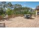 Large backyard deck with outdoor dining table and hanging chair, great for enjoying the wooded view at 3863 Rosebay Way, Conyers, GA 30094