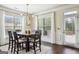 Sunlit dining area features a modern chandelier, large windows, and a rustic dining table at 3863 Rosebay Way, Conyers, GA 30094