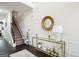 Bright entryway boasts hardwood floors, staircase with chair lift, and console table with a decorative mirror at 3863 Rosebay Way, Conyers, GA 30094