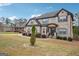 Two-story brick home features a well-manicured lawn and an inviting front porch with stone accents at 3863 Rosebay Way, Conyers, GA 30094