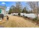 Backyard featuring a stone patio, lush landscaping, and a classic white picket fence at 211 Collierstown Way, Peachtree City, GA 30269