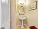 Pedestal sink with decorative mirror and lighting in half bath at 211 Collierstown Way, Peachtree City, GA 30269