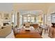 Bright dining room featuring hardwood table set, opening to a sunroom, with neutral decor and plenty of natural light at 211 Collierstown Way, Peachtree City, GA 30269