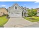 Well maintained home featuring a three-car garage, stone accents, and a driveway at 211 Collierstown Way, Peachtree City, GA 30269