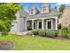 Charming home featuring a stone facade, white pillars, tidy bushes, and well manicured landscaping at 211 Collierstown Way, Peachtree City, GA 30269