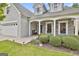 Charming home featuring a stone facade, white pillars, tidy bushes, and well manicured landscaping at 211 Collierstown Way, Peachtree City, GA 30269
