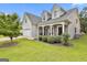 Charming home featuring a stone facade, white pillars, tidy bushes, and a well manicured lawn at 211 Collierstown Way, Peachtree City, GA 30269