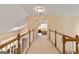 Upstairs hallway with carpet and wooden railing leading to a bedroom with a floral bedspread at 211 Collierstown Way, Peachtree City, GA 30269