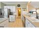 Bright kitchen with stainless steel refrigerator, sink, and tiled backsplash at 211 Collierstown Way, Peachtree City, GA 30269