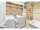 Functional laundry room with washer, dryer, shelving, and utility sink at 211 Collierstown Way, Peachtree City, GA 30269