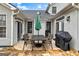 An outdoor living area with a stone patio and an outdoor dining set with a grill at 211 Collierstown Way, Peachtree City, GA 30269