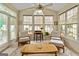 Bright and airy sunroom with a ceiling fan, large windows, and a cozy seating area at 211 Collierstown Way, Peachtree City, GA 30269