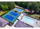 Aerial view highlighting community amenities: swimming pool and tennis courts near lush landscapes at 2304 Larchmont Ct, Villa Rica, GA 30180