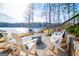 Inviting lake-view patio with white Adirondack chairs and a fire pit perfect for outdoor relaxation at 2304 Larchmont Ct, Villa Rica, GA 30180
