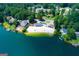 Aerial view of a waterfront property with a private sandy beach, boat docks, and surrounding lush trees at 2304 Larchmont Ct, Villa Rica, GA 30180