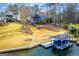 Back exterior view of a home with a lake dock and green lawn at 2304 Larchmont Ct, Villa Rica, GA 30180