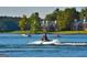 Scenic lake view featuring waterfront homes and people enjoying water sports on a sunny day at 2304 Larchmont Ct, Villa Rica, GA 30180
