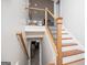 Wooden staircase with black iron spindles leading to the upper and lower levels of the home at 2304 Larchmont Ct, Villa Rica, GA 30180