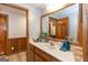 Bathroom with wooden cabinetry, large mirror, and neutral countertops at 222 Providence Rd, Fayetteville, GA 30215