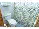 Bathroom with a white toilet and a shower with leaf-patterned curtain at 222 Providence Rd, Fayetteville, GA 30215