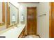 Bathroom featuring a long vanity with sink, wood cabinets and trim with a door at 222 Providence Rd, Fayetteville, GA 30215