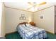 Comfortable bedroom with wooden trim, a ceiling fan, and a cozy bed with a blue and white quilt at 222 Providence Rd, Fayetteville, GA 30215