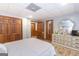 Bedroom with light gray walls, wood-look vinyl floors, and decorative closet doors at 222 Providence Rd, Fayetteville, GA 30215
