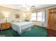 Spacious bedroom with ceiling fan, window, and soft green carpeting with furniture at 222 Providence Rd, Fayetteville, GA 30215