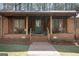 Inviting home with a welcoming front porch, complete with rocking chairs, swing and brick detailing at 222 Providence Rd, Fayetteville, GA 30215