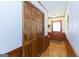 Hallway featuring wood wainscoting, bi-fold wood closet, wood door, and hardwood floors at 222 Providence Rd, Fayetteville, GA 30215
