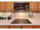 Close up view of kitchen featuring cooktop, microwave, and cabinets at 222 Providence Rd, Fayetteville, GA 30215