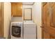 Laundry room with side-by-side washer and dryer, oak cabinets, and tile floors at 222 Providence Rd, Fayetteville, GA 30215