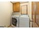 Laundry room with side-by-side washer and dryer, oak cabinets, and tile floors at 222 Providence Rd, Fayetteville, GA 30215