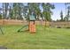 Spacious backyard featuring a playset, lush green grass, and privacy fence at 734 Lanarck Way, Peachtree City, GA 30269