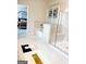 Bright bathroom featuring glass enclosed shower, soaking tub, and view into bedroom at 734 Lanarck Way, Peachtree City, GA 30269