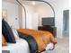 Modern bedroom featuring a four-poster bed with stylish linens, and a television atop a dresser at 734 Lanarck Way, Peachtree City, GA 30269