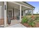 Charming covered front porch featuring rocking chairs and colorful flower gardens around the entrance at 734 Lanarck Way, Peachtree City, GA 30269