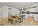 Contemporary kitchen featuring white cabinetry, a wood dining table, and modern light fixtures at 734 Lanarck Way, Peachtree City, GA 30269